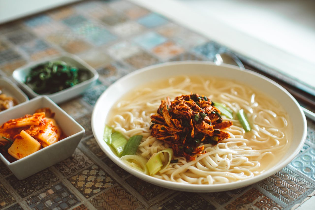 Enjoy a hearty Asian noodle dish with kimchi and vegetables in a warm setting.